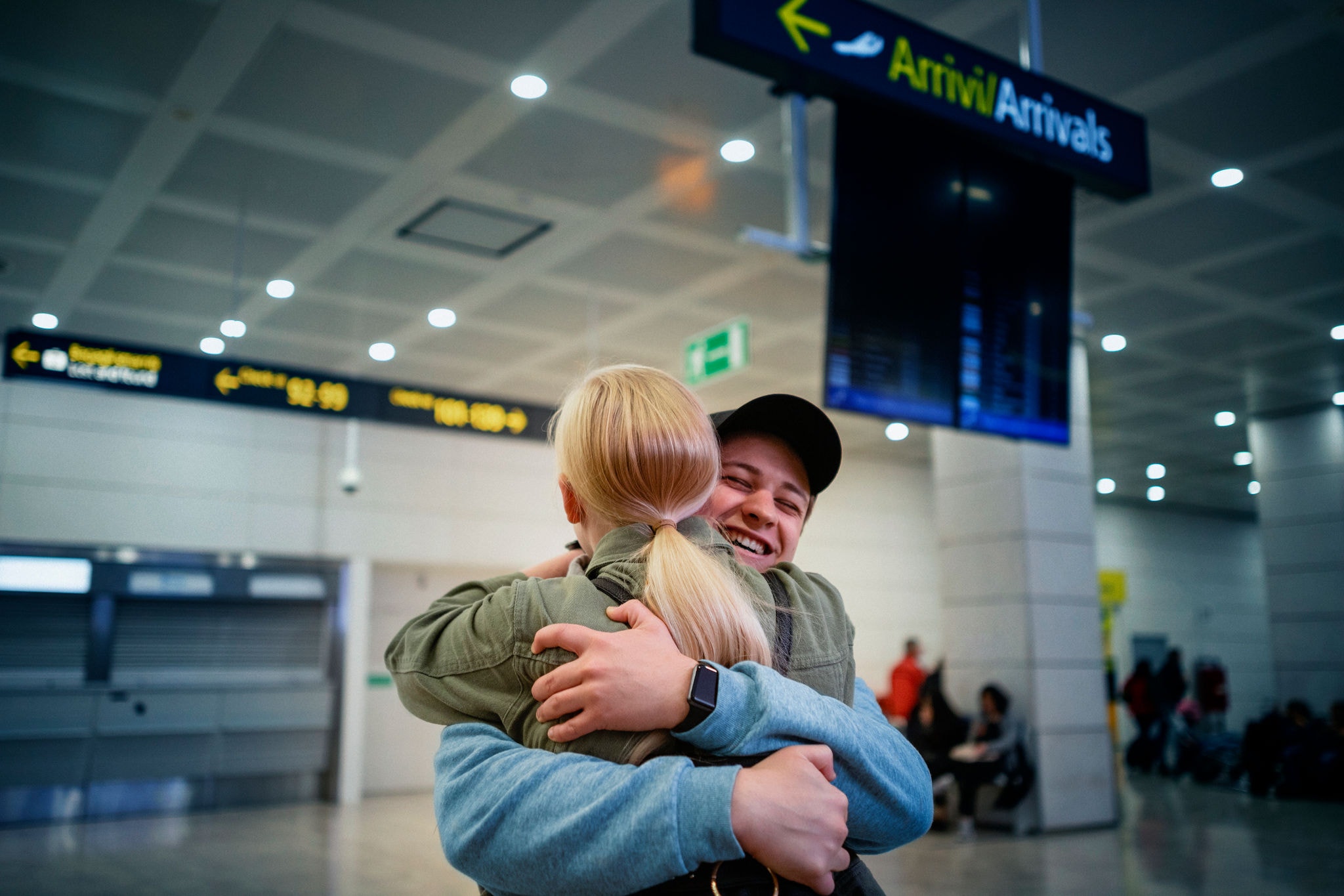 A young woman is hugging her boyfriend upon arrival in the airport A young woman is hugging her boyfriend upon arrival in the airport